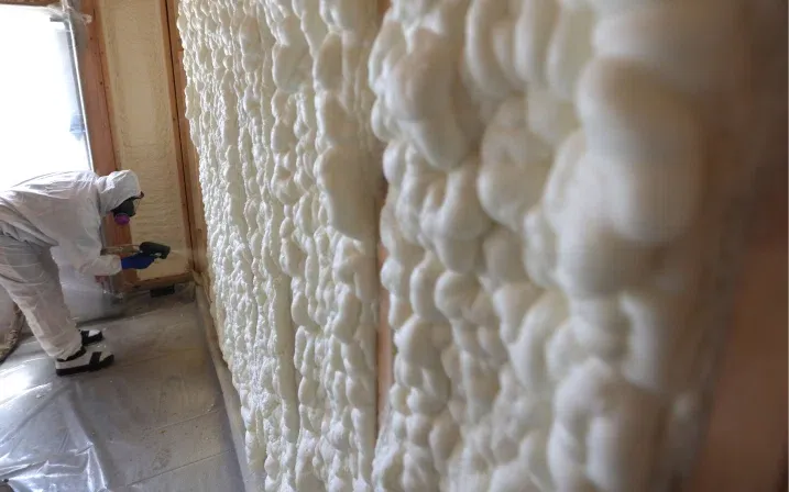 Installer applying spray foam to a wall